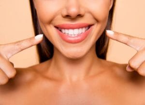 woman pointing to her veneers