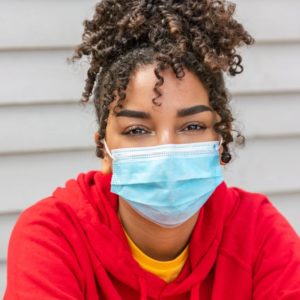 Woman with curly hair wearing a surgical mask
